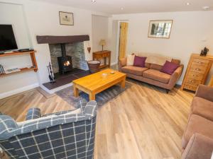 a living room with a couch and a fireplace at Ffrwdd Galed Uchaf in Tregarth