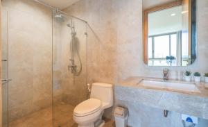 a bathroom with a shower and a toilet and a sink at Sandbox Beachfront Villa 3 in Ban Krathing Lai