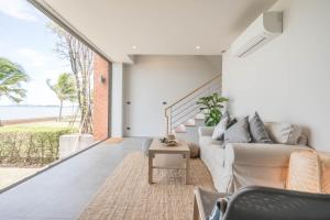 a living room with a couch and a view of the ocean at Sandbox Beachfront Villa 3 in Ban Krathing Lai