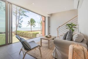 a living room with a couch and a view of the ocean at Sandbox Beachfront Villa 3 in Ban Krathing Lai