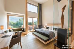 a bedroom with a bed and a desk in a room at Klosterhof – Alpine Hideaway & Spa in Bad Reichenhall