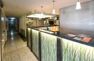 a lobby with a counter with plants on it at HOTEL Am Spichernplatz in Düsseldorf