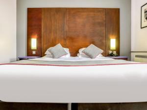 a bedroom with a large bed with a wooden headboard at OYO Flagship Sheffield City Centre in Sheffield