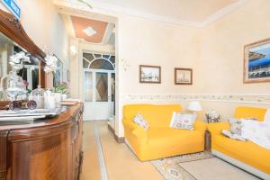 a living room with a yellow couch and a table at Villino Simona in Viareggio