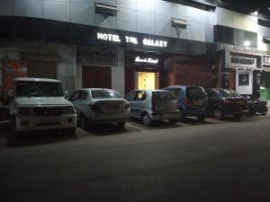 a row of cars parked in front of a building at Hotel The Galaxy in Mirzāpur