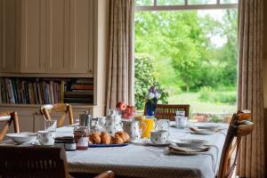 a table with croissants and bread on it with a window at The Hayloft, Wall End Farm in Leominster