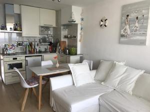 a living room with a white couch and a kitchen at Apartment with a great sea view in the best location of Santa Ponsa in Santa Ponsa