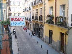 une rue vide avec un panneau sur le côté d'un bâtiment dans l'établissement Hostal Casanova, à Madrid