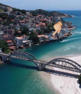 uma ponte sobre um corpo de água ao lado de uma cidade em Casa Marambaia no Rio de Janeiro