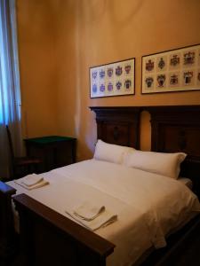 ボローニャにあるPalazzo Bargellini Panzacchi Rooms & Apartmentのベッドルーム1室(ナプキン2本付)