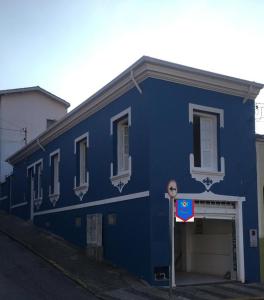 a blue building with a garage in front of it at Pousada Casa de Bragança II in Bragança Paulista