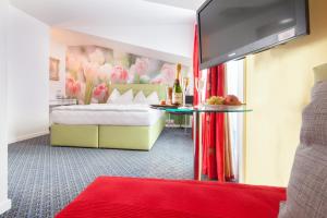 ゾロトゥルンにあるホテル アンバサダーのベッドと赤い敷物が備わるホテルルームです。