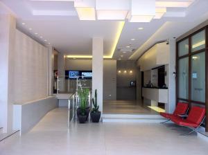 un vestíbulo de oficina con sillas rojas y plantas en Las Rocas Playa Hotel, en Castro Urdiales