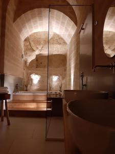 a bathroom with a sink and a bath tub at Endea Suite Rooms in Matera