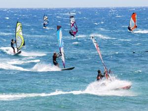 a group of people windsurfing in the ocean at TEJITA BEACH APARTMENT in El Médano