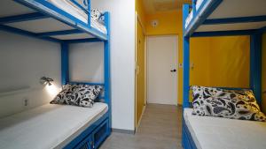 two bunk beds in a room with yellow walls at Way Guesthouse in Jeonju