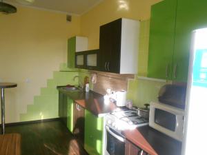 a green kitchen with a stove and a microwave at Цитадель к15 in Omsk