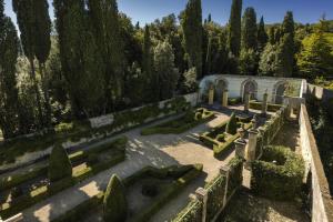 a garden with hedges and a building and trees at Torre a Cona Wine Estate in Florence