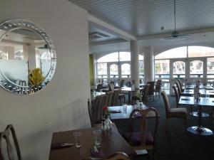 a dining room with tables and a mirror on the wall at Boathouse Hotel in Hythe