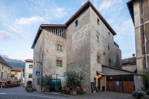 un antiguo edificio de piedra con techo en Flurin Suites, en Glorenza