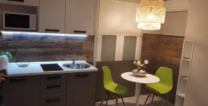 cocina con fregadero y mesa con sillas verdes en Apartments Giron, en Dubrovnik 34 fotos más