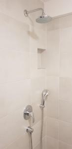 a shower with a shower head in a bathroom at Apartments Giron in Dubrovnik