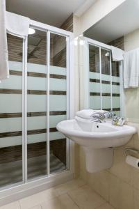 uma casa de banho branca com um lavatório e um chuveiro em Boutique Urban Madrid Serrano em Madri