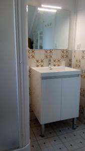 een badkamer met een witte wastafel en een spiegel bij BOYRIE Daniel et Hélène in Gavarnie