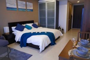 a bedroom with a large bed with blue pillows at Beachfront Executive Studio Mae Phim in Rayong +22 photos