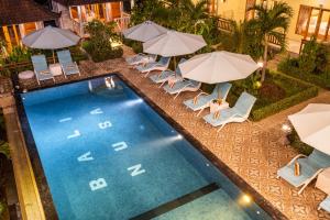 an overhead view of a pool with chairs and umbrellas at Bali Nusa Cottage in Nusa Lembongan