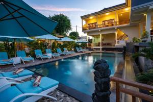 a pool at a hotel with chairs and umbrellas at Bali Nusa Cottage in Nusa Lembongan