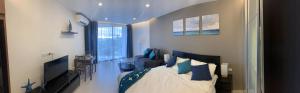 a bedroom with a bed with blue pillows at Beachfront Executive Studio Mae Phim in Rayong