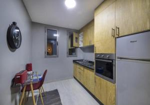 a kitchen with a refrigerator and a table in it at Palms Edge Villas avec Piscine & Jardin Privés in Marrakech