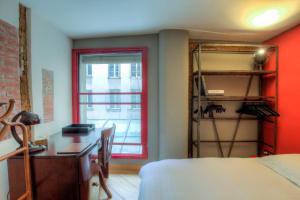 a red room with a desk and a window at Appartement Luxe Montorgueil bail mobilité Opera Louvre in Paris