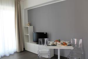 a living room with a table with chairs and a tv at Residence Pola in Catania