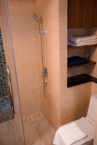 a shower with a glass door and a toilet in a bathroom at Beachfront Executive Studio Mae Phim in Rayong