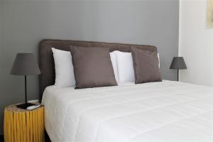 a bedroom with a large white bed with two lamps at Residence Pola in Catania