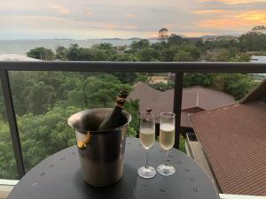 a bucket with a bottle of champagne and two glasses on a table at Beachfront Executive Studio Mae Phim in Rayong