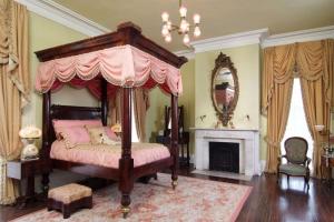 1 dormitorio con cama con dosel y chimenea en Nottoway Plantation and Resort, en White Castle