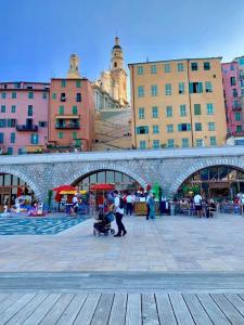 a group of people in a city with buildings at Les Sablettes in Menton