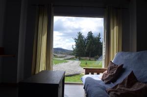 Habitación con ventana, sofá y vistas. en Altos Del Molino en Trevelín