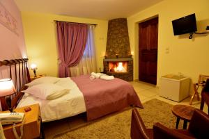 Synikia Mesi TrikalonにあるMavraganeikoのベッドと暖炉付きのホテルルーム