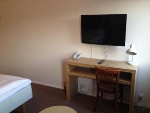 a room with a desk, chair and a television at Ro Hotel in Geilo