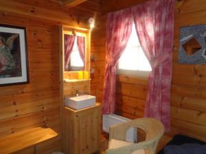 a bedroom of a log cabin with a window at Family Home in Fáskrúðsfjörður +37 photos