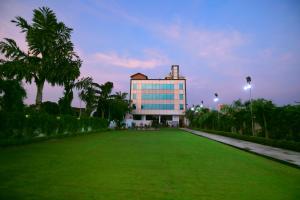a large building with a green lawn in front of it at V One Pride in Jaipur
