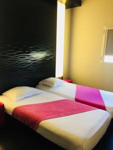 a hotel room with a bed and a window at Hôtel Gardenia Bordeaux Est in Yvrac