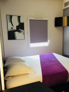a bedroom with a white bed and a blue wall at Hôtel Gardenia Bordeaux Est in Yvrac