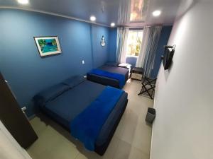a bedroom with two beds and a blue wall at Palmare House in San Andrés +22 photos