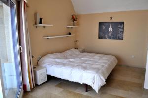 een slaapkamer met een wit bed in een kamer met een raam bij La Paz, ático, 2 dormitorios, Moreira, by Bookindenia in Moraira
