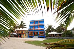 un edificio blu con palme di fronte di Hotel Royal Blue & Golf Cart Rental a San Pedro